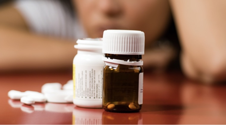 a different angle of pills spilling out of a bottle